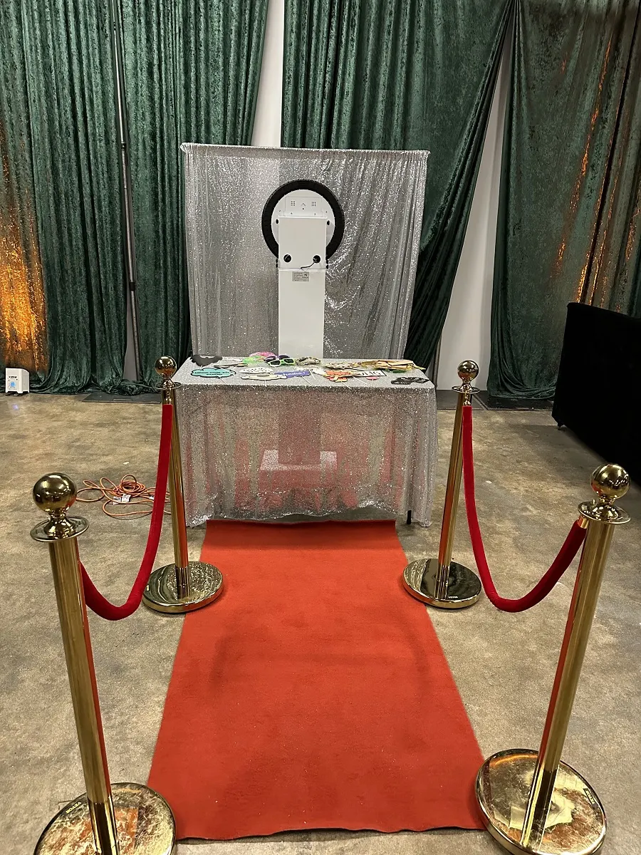 Print photo booth with silver sequin backdrop and red carpet